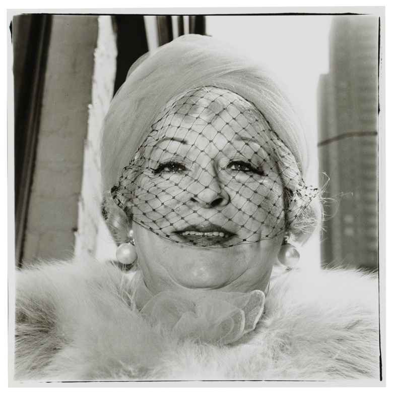 Diane Arbus (1923-1971), Woman with a veil on Fifth Avenue, New York City, 1968. Gelatin silver print, printed later by Neil Selkirk. Image 14¾ x 14⅝ in (37.5 x 37.1 cm). Sheet 19¾ x 15⅞ in (50.2 x 40.3 cm). This work is number 27 from an edition of 75. Estimate$12,000-18,000. This work is offered in The Comedians online auction, 5-10 April