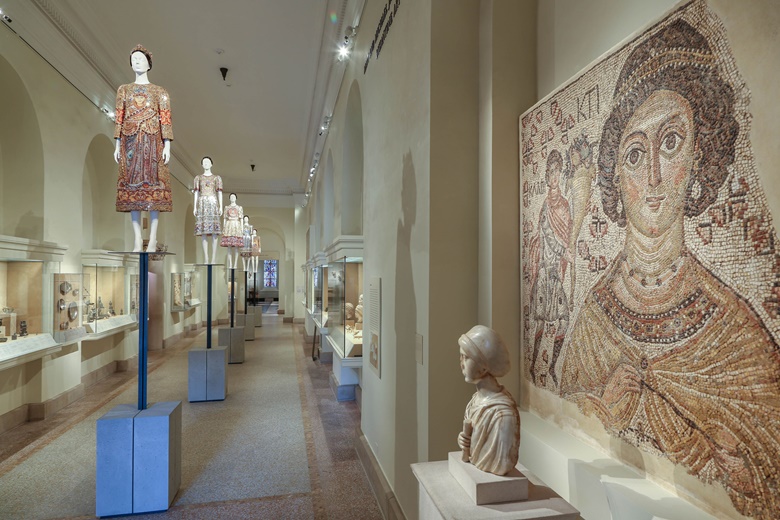 The Mary and Michael Jaharis Galleries for Byzantine Art. The dress on the first mannequin is by Domenico Dolce and Stefano Gabbana for Dolce & Gabbana, ensemble, autumnwinter 2013-14. On the right a fragment of a Byzantine floor mosaic with a personification of Ktisis, 500-550, said to have inspired Docle & Gabbana’s creation. Image © The Metropolitan Museum of Art