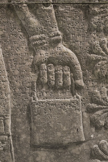 Fine rows of cuneiform script run across the relief, recalling Ashurnasirpal’s achievements