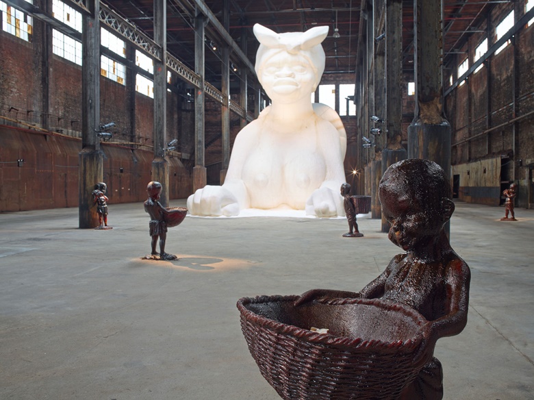 Kara Walker (b. 1969), At the behest of Creative Time Kara E. Walker has confected A Subtlety, or the Marvelous Sugar Baby, an Homage to the unpaid and overworked Artisans who have refined our Sweet tastes from the cane fields to the Kitchens of the New World on the Occasion of the demolition of the Domino Sugar Refining Plant. A project of Creative Time. Domino Sugar Refinery, Brooklyn, NY, May