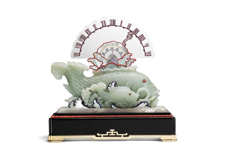 逆跳指针鲤鱼时钟，23 × 23 × 11公分，1925年，卡地亚巴黎。铂金、黄金、无色水晶、雕刻青玉（鲤鱼）、黑曜石（基座）、紫红色漆面、黑蓝红色珐琅、玫瑰式切割钻石、凸圆形祖母绿、珍珠、珊瑚、珍珠贝母。8日动力储存长方形机芯，镀金，逆跳指针，标准擒纵装置，双金属平衡摆轮，扁平摆轮游丝。Marian Gérard, Collection Cartier © Cartier