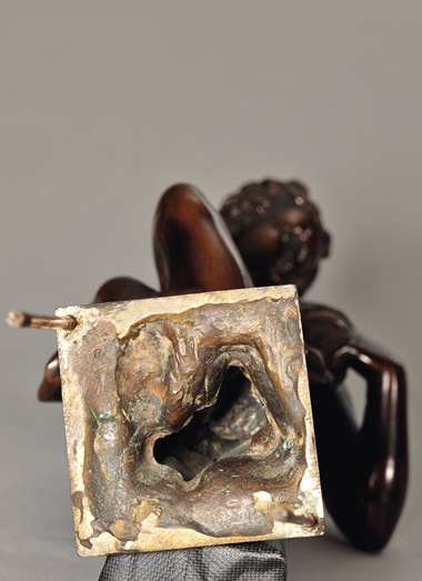 The underneath of the bronze statue, revealing a cavity and the original colour of the un-oxidised bronze