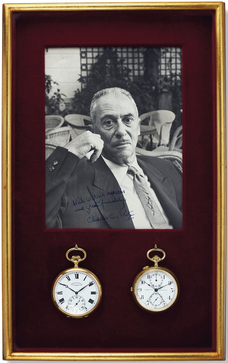 The two watches in a frame alongside a signed photograph of Charles Ritz