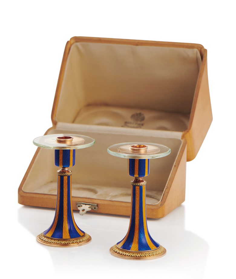 A pair of rare guilloché enamel, rock crystal and two-colour gold and silver candlesticks marked Fabergé, 1908-1917. 2¾ in (7.2 cm) high. Estimate £40,000-60,000. Offered in Russian Art on 7 June 2021 at Christie’s in London