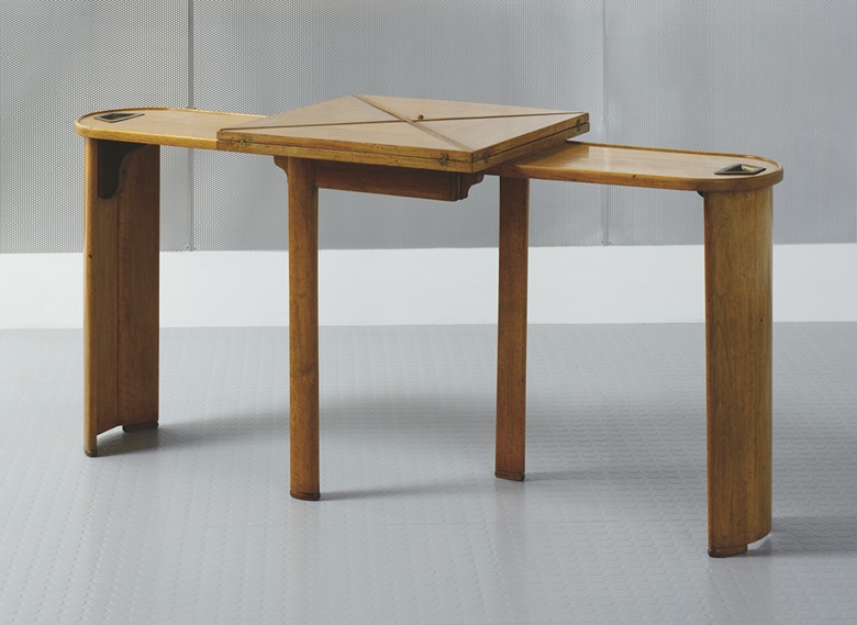 Pierre Chareau (1883-1950), Table de jeu mouchoir ‘MB 241a’, vers 1926. Walnut, brass, felt and partly gilt leather. Extended  26⅜ x 57 x 41 in (67 x 145 x 104 cm). Folded 27⅛ x 57 x 26⅝ in (69 x 145 x 52.5 cm). Estimate €80,000-120,000. Offered in Annie et Jean Dalsace, Les collections de la Maison de Verre on 7 October 2021 at Christie’s in Paris