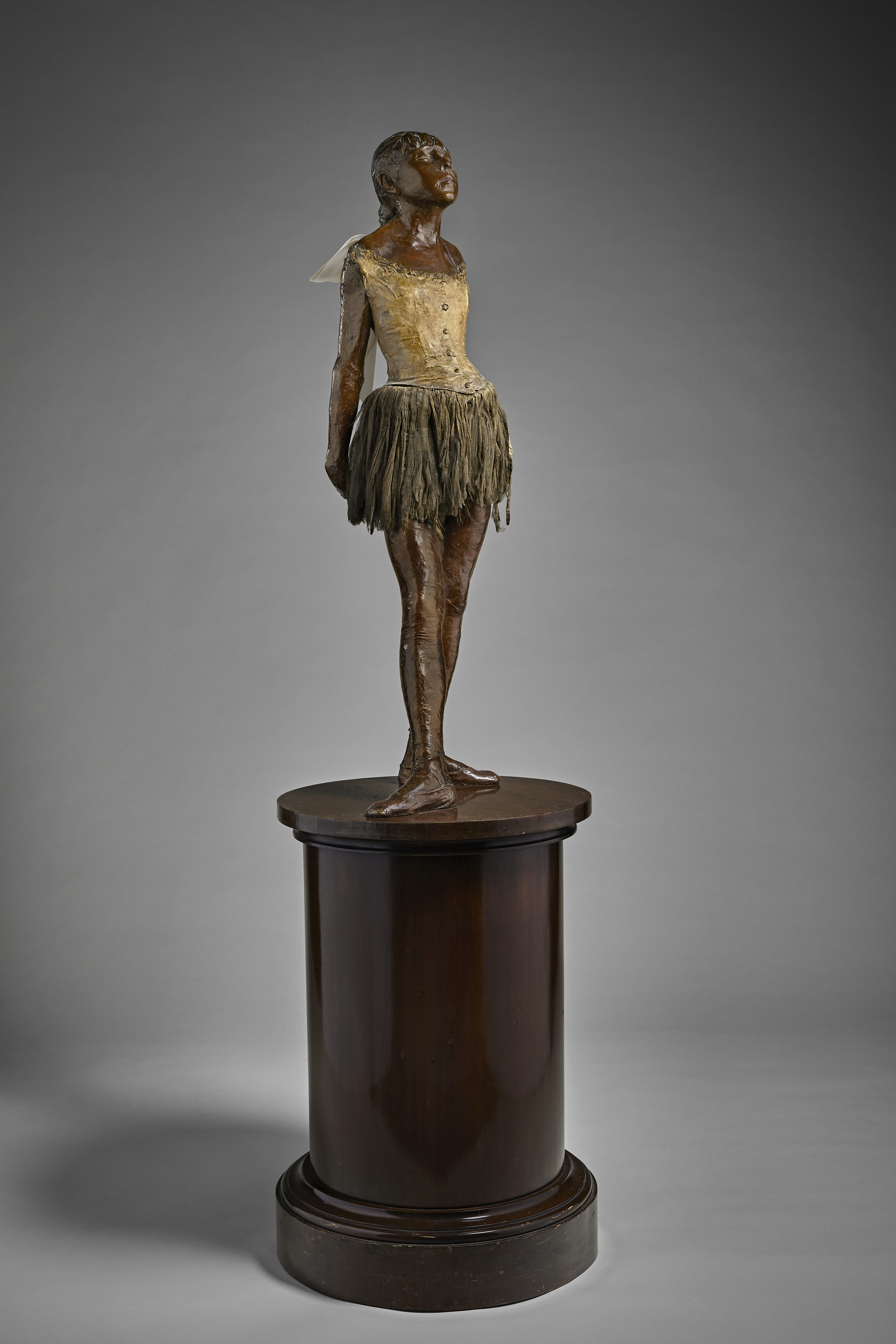 Edgar Degas (1834-1917), Petite danseuse de quatorze ans, cast in 1927. Bronze with brown patina with muslin skirt and satin hair ribbon on wooden base. Height (excluding base) 40½ in (102.9 cm). Estimate $20,000,000-30,000,000. Offered in The Collection of Anne H. Bass on 12 May 2022 at Christies in New York