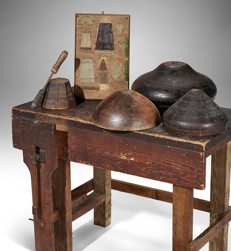 Tiffany Studios, Workbench and tools from the former collection of John Dikeman, prior to 1932. Favrile glass, carved wood, copper, iron. Comprising a workbench, four wooden shade molds, one soldering iron, and a lampshade identification chart with selections of Favrile Fabrique glass tiles. Workbench 33 x 28 x 45 in (83.8 x 71.1 x 114.3 cm). Sold for $75,600 in Tiffany Masterworks from the Garden
