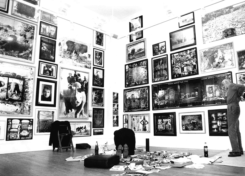 Peter Beard, kneeling forward in the centre of the picture, preparing for his exhibition at CAMERA WORK, 1998. Right, Peter Tunney, Beard’s New York gallerist at the time. Photo © CAMERA WORK Gallery