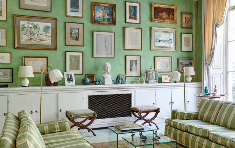 Works of art, objects and furniture in the drawing room, including a pair of north Italian mahogany and parcel-gilt X-frame stools, and a group of Chinese Fahua porcelain vessels and figures. On the coffee table is a group of four figures by Ivor Abrahams, R.A. Offered in Churchill to Eden The Collection of The Earl and Countess of Avon on 21 October 2022 at Christie’s in London