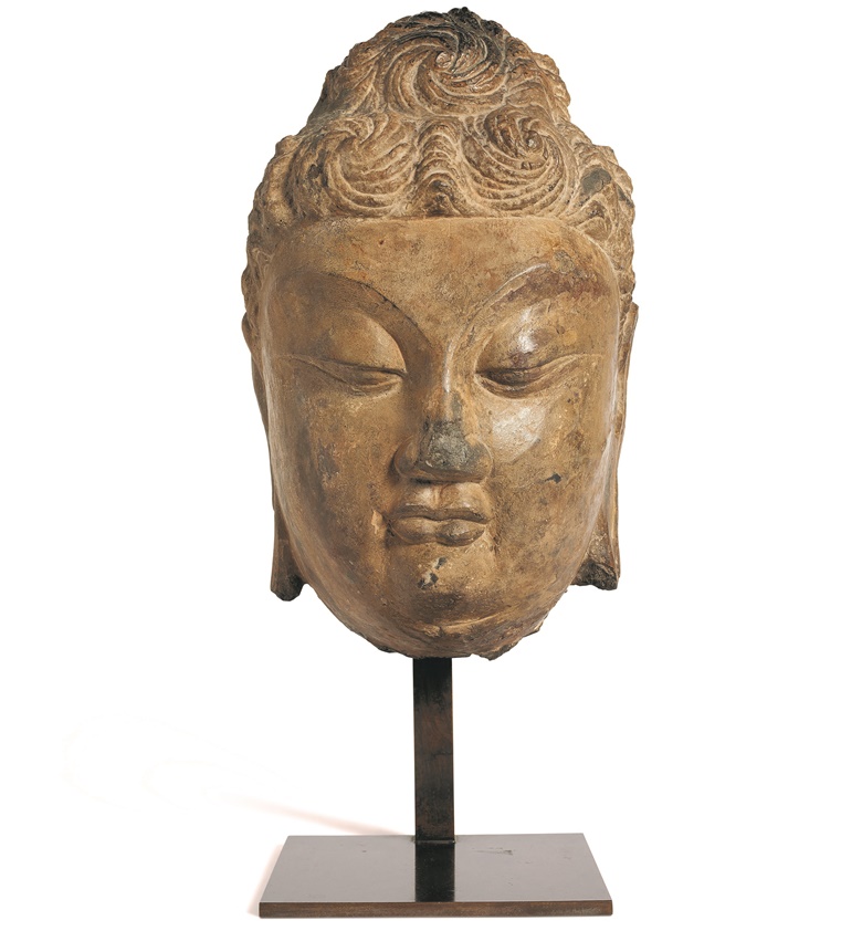 Stone buddha head, China, Yuan-Ming Dynasty (1279–1644) or earlier. H 35.5 cm (14 in), metal base. Estimate €30,000-40,000. Offered in Collections on 28 October at Christie’s Paris