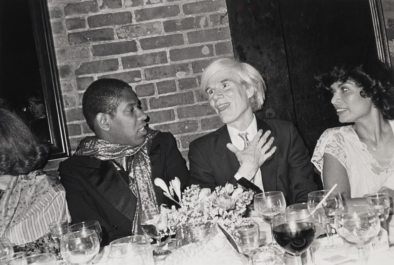 Bob Colacello (b. 1947), André Leon Talley, Andy Warhol and Bianca Jagger at her birthday dinner, Mortimers, 1981. Gelatin silver print. 32 x 45 in (81.3 x 144.4 cm). Estimate $800-1,200. Offered in The Collection of André Leon Talley on 15 February 2023 at Christie’s in New York
