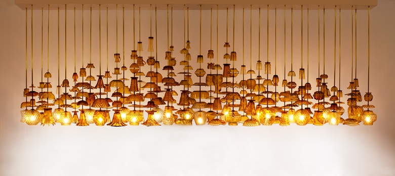 Stuart Haygarth (b. 1966), Flame 2013 (2013). Vintage amber glassware, brass rods, powder coated aluminium. Variable size. ‘My work revolves around everyday objects... categorised and presented in such a way that they are given new meaning’